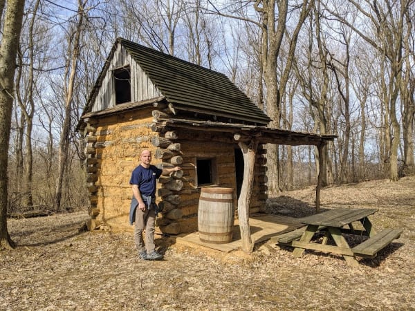 Jack standing in front of a cabin at Fort Duffield.