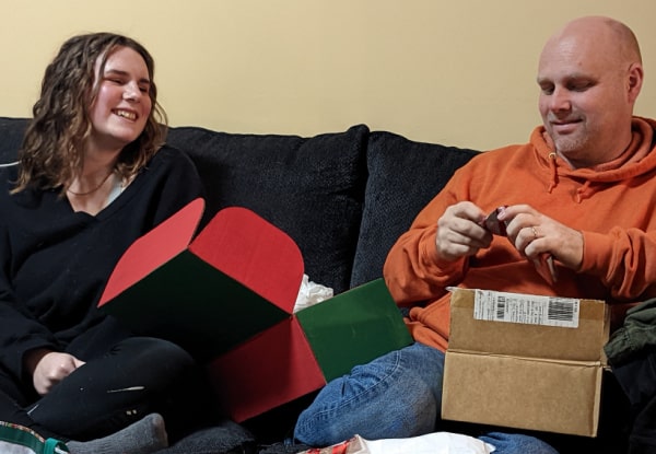 Dad opening a gift from his daughter. 