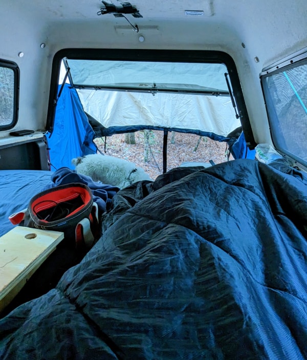 Me and our dog Dexter. Warm and cozy inside our truck cap camper at the family campground in Merchants Millpond State Park, NC.