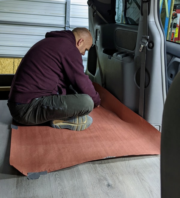 Making a paper template for the edge pieces of the vinyl plank flooring for the minivan camper. 