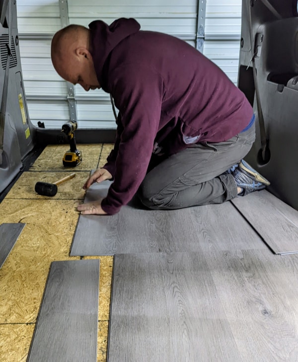 Putting down vinyl plank flooring on our now level minivan floor. 