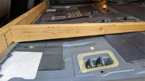 Making sure that the first floor beam is doing its job in creating a level floor in the minivan to camper van conversion. 